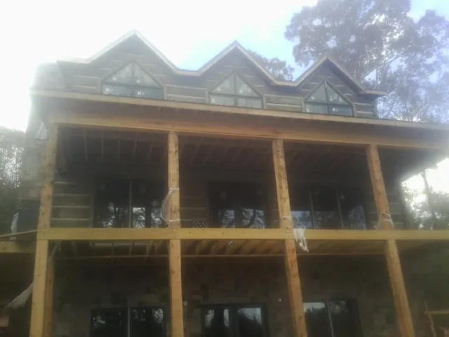 Dormers and porch framing on a large log home under construction — Roof Coating work by our crew in Phoenicia