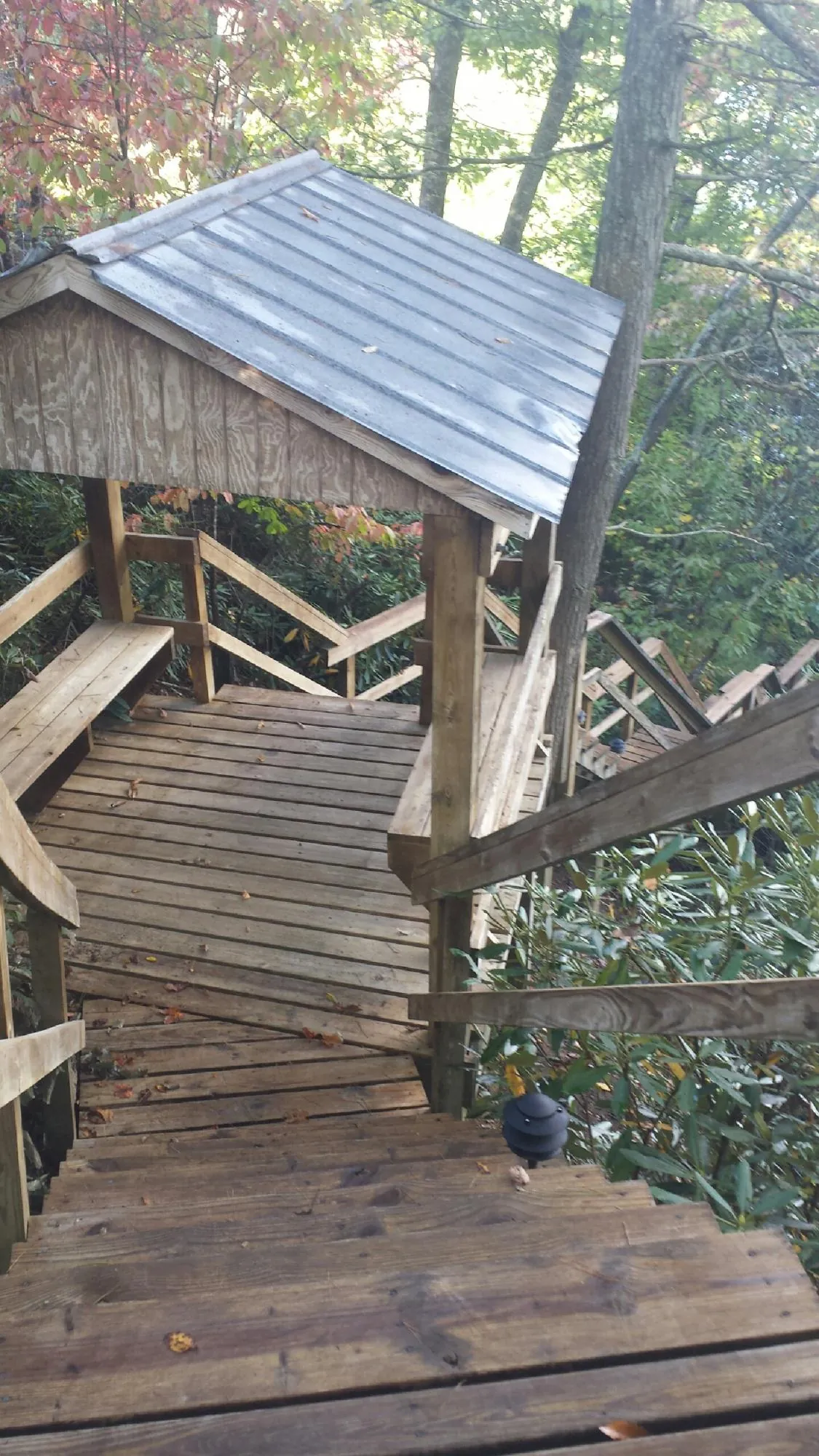 Metal roofed shelter over wooden steps on a wooded walkway — Skylight Repair & Installation work by our crew in Phoenicia