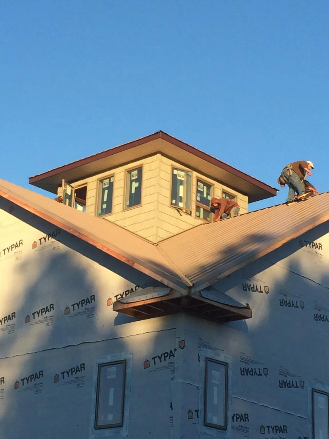 Roofers working around a rooftop cupola on a new metal roof at sunset — Roof Waterproofing in Phoenicia by Roofing Brothers